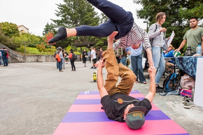 two students doing acro yoga